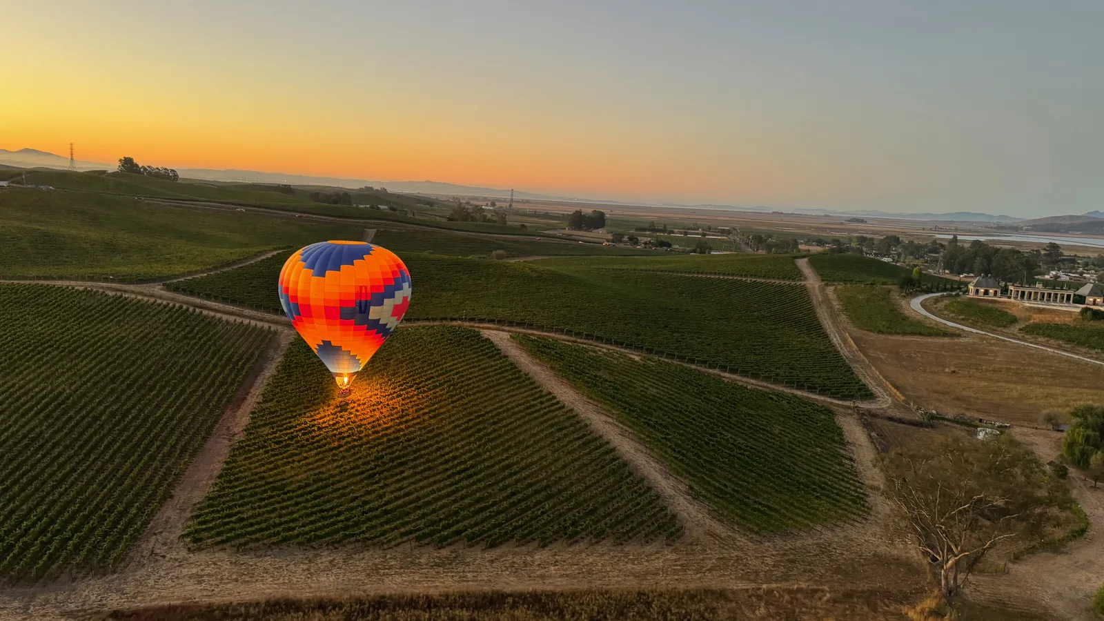 Balloon over wide, flat open farmland and quilted fields in Yolo County