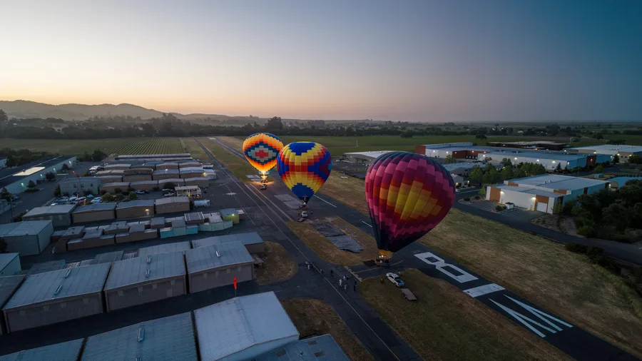 Hot air balloons inflating at dawn at Sonoma Skypark, seen from above