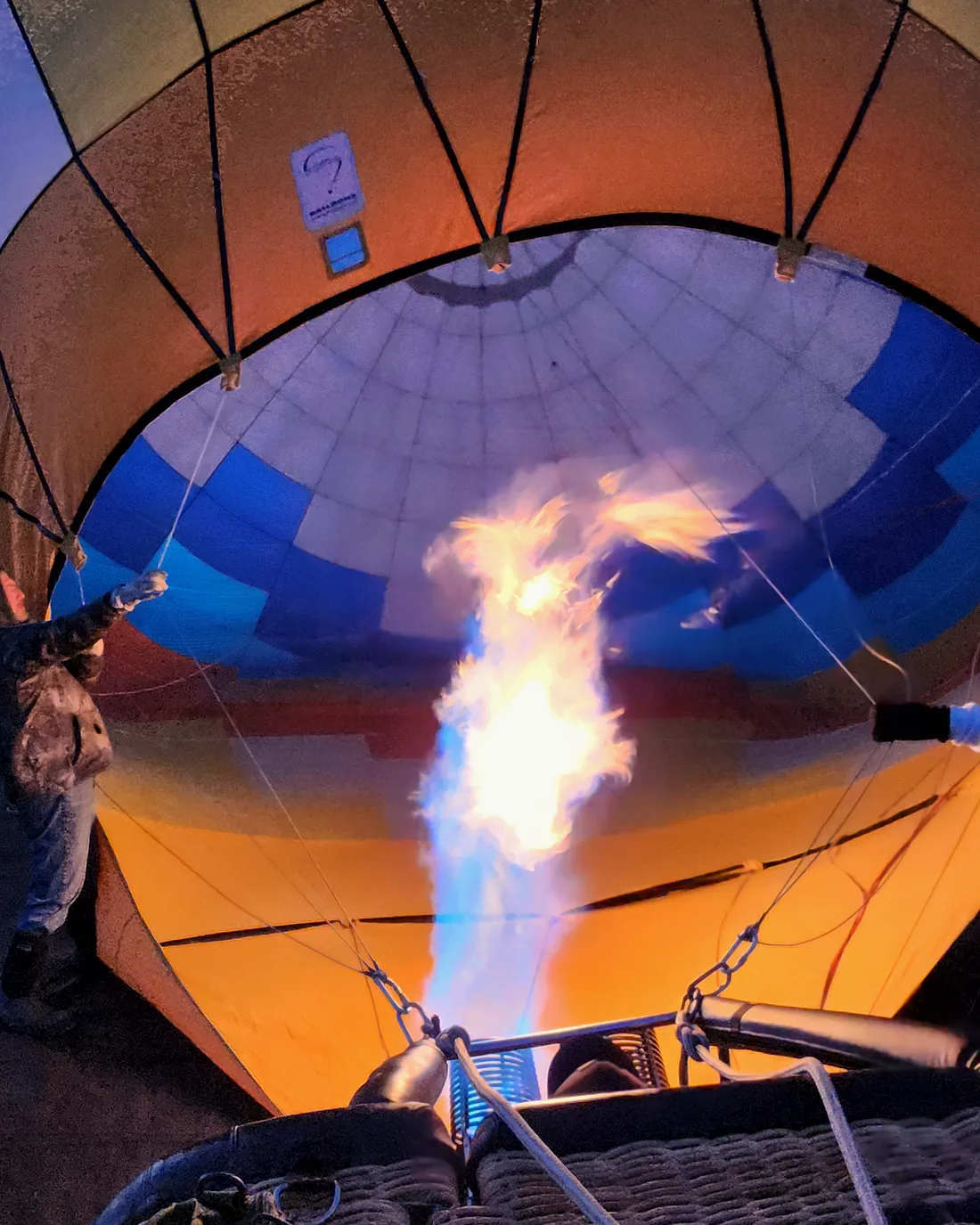 Burners firing as two balloons inflate side by side at dawn