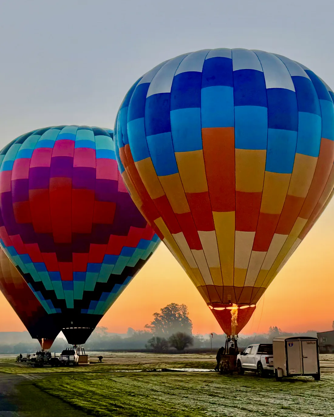 Two balloons glowing at first light on the Sonoma Skypark runway